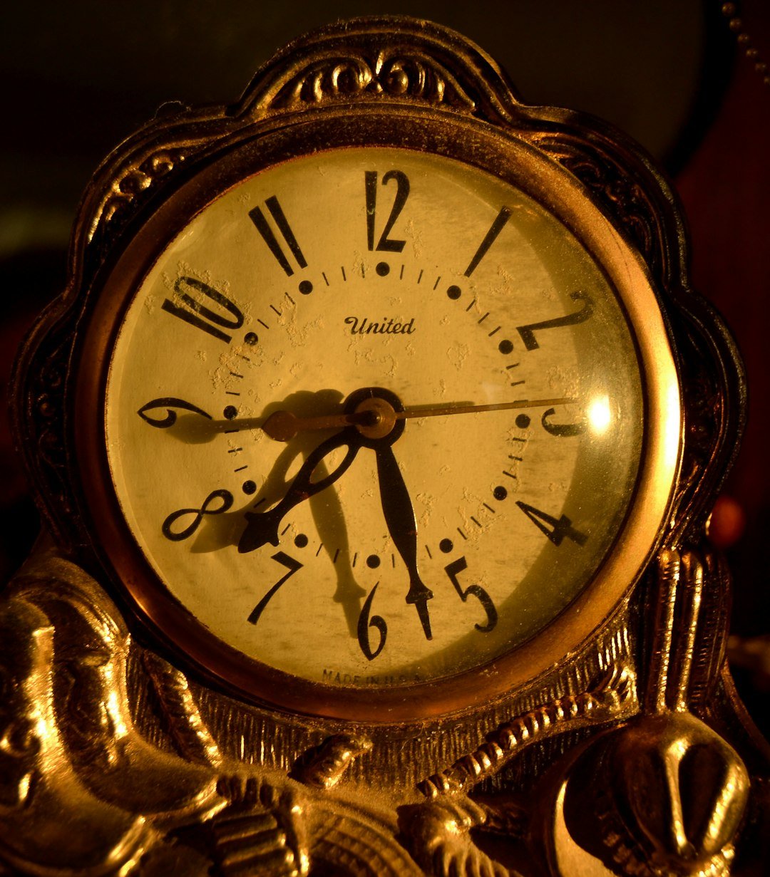 dusty gold clock in low light close up