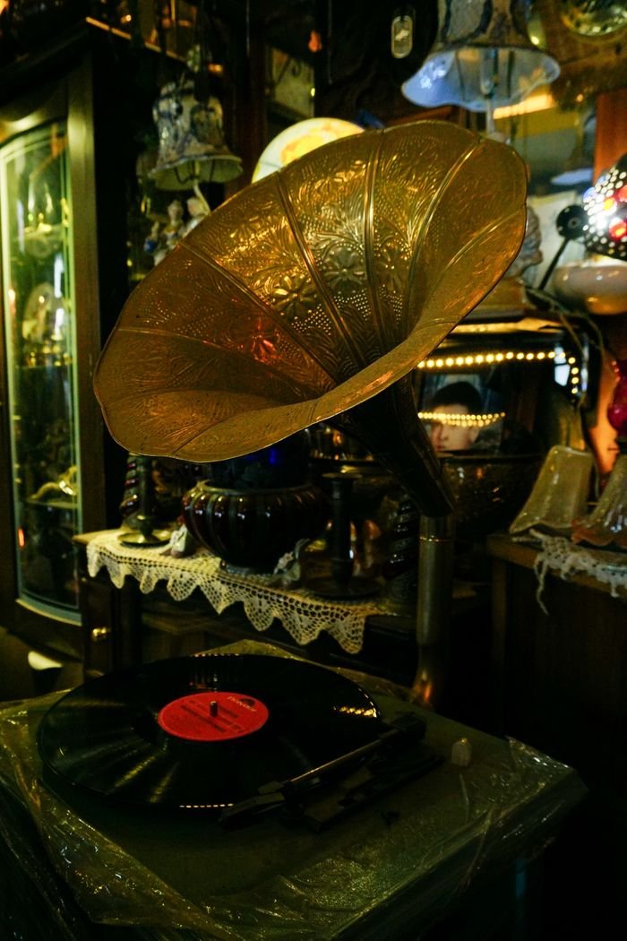 A beautiful vintage gramophone and vinyl record displayed in a charming antique shop setting.