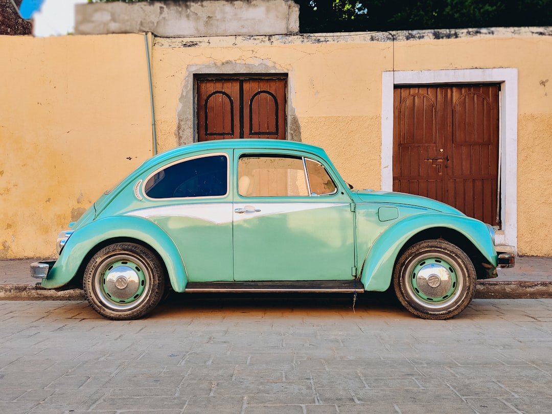teal-volkswagen-beetle-parked-near-brown-house-xbrqfr2bqni